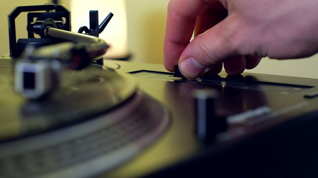 Male Hand Pushing Pitch Control Fader on Retro Turntable Vinyl