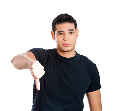 Young man giving thumbs down gesture, white background 