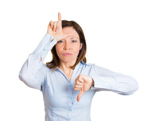 Portrait angry middle aged woman giving loser sign, gesture
