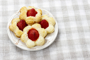 Puff pastry cookies in flower shape filled with strawberries