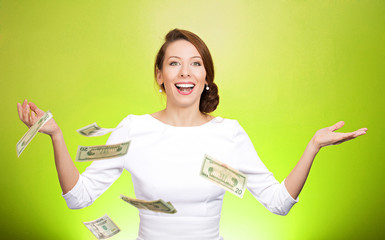 Money thrown in the air by excited woman on green background 