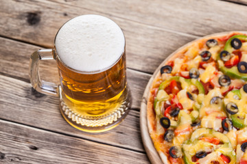 Obraz na płótnie Canvas pizza on the table with a glass of beer