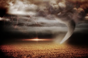 Stormy sky with tornado over field