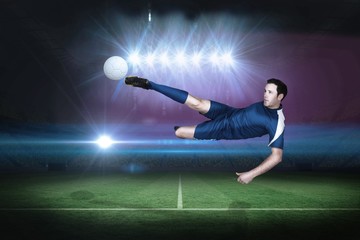 Fototapeta na wymiar Football player in blue kicking