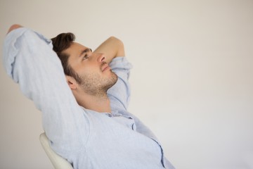 Obraz premium Casual businessman relaxing at desk leaning back