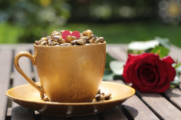 goldene Kaffeetasse mit Kaffeebohnen