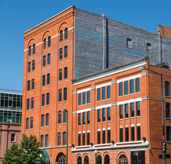 Fototapeta premium Old Red Brick Buildings with Blue Windows Under Clear Sky