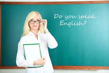 School teacher near blackboard in classroom
