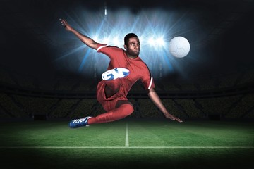 Football player in red kicking - Powered by Adobe