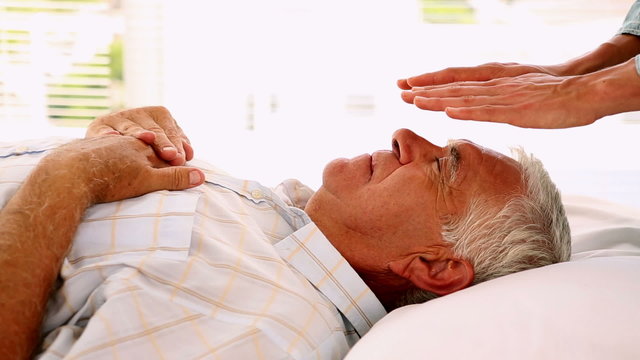 Senior man getting reiki therapy