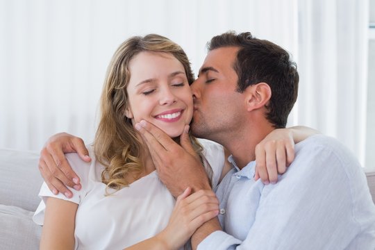 Close-up of a man kissing happy woman