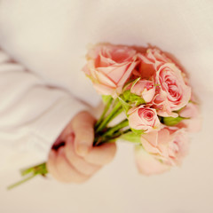 Newborn baby hand holding bouquet