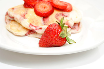 A Ripe Strawberry in Front of Fruity Hotcakes