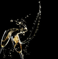 Glasses of champagne with splash, on black background © Africa Studio