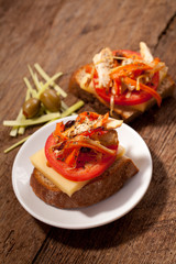 Sandwich with tomato on a table with meat, tomato and olives