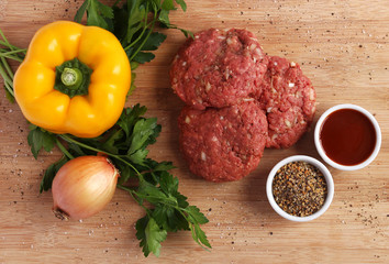 Raw beef patties with vegetables, barbecue sauce and spices - 64439922