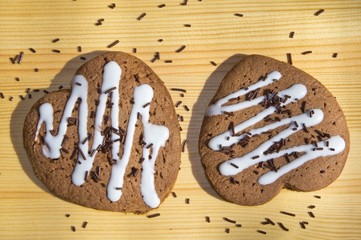 gingerbread hearts with chocolate sprinkles on a wooden table