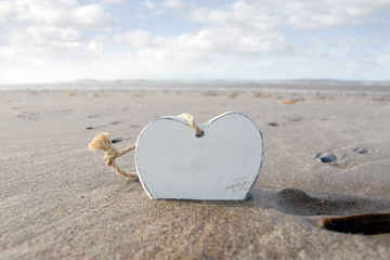 Fototapeta premium single wooden love heart in the sand