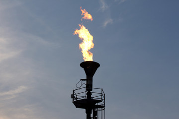 Oil burning torch against  blue sunset sky