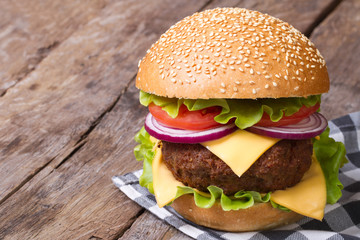 big hamburger with fresh vegetables, cheese and meat