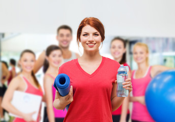 smiling girl with bottle of water after exercising