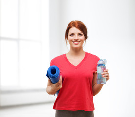 smiling girl with bottle of water after exercising