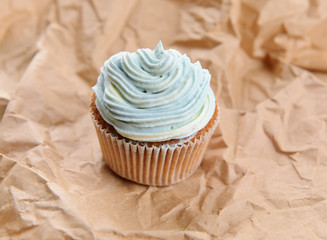 Tasty cupcake with butter cream, on color background