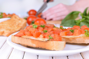 Delicious bruschetta with tomatoes on plate on table close-up