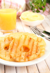 Juicy grilled pineapple on plate on table close-up