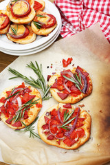 Small pizzas on baking paper close up