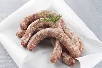 chipolata sausages with herbs in baking paper