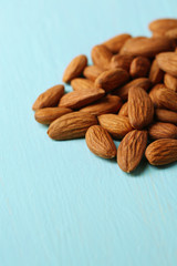 Almonds on color wooden background