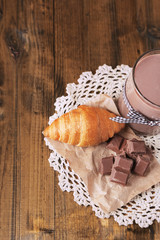 Chocolate milk in glass, on wooden table background