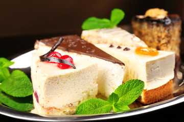 Assortment of pieces of cake, on dark background © Africa Studio