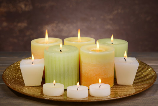 Beautiful candles on table on brown background