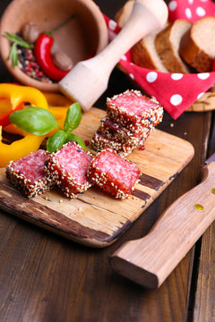 Composition of knife,    sliced salami sausage with sesame,