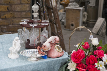 rose of artificial flowers and old pink phone with disk