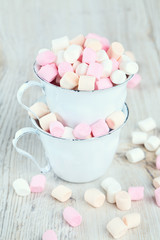 Obraz na płótnie Canvas marshmallows in metallic cups on wooden table