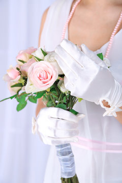 Beautiful bride in white gloves holding wedding bouquet,