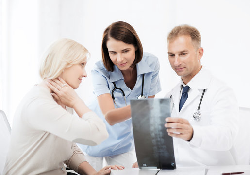doctors with patient looking at x-ray