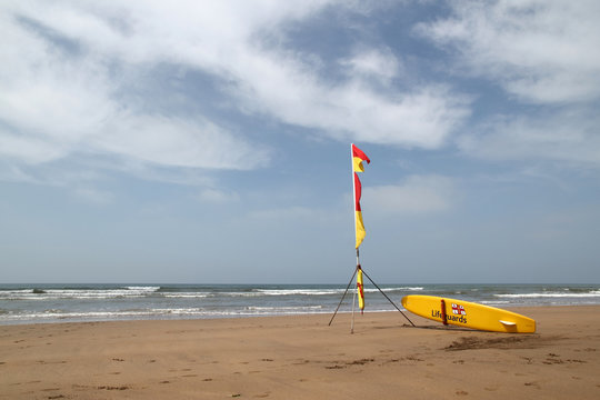Lifeguards yellow surf with flags on an english beach
