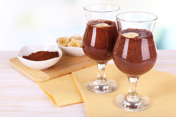 Cocktails with banana and chocolate on table on light