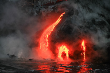 Fototapeta na wymiar Red hot lava flowing into Pacific Ocean on Big Island, Hawaii 