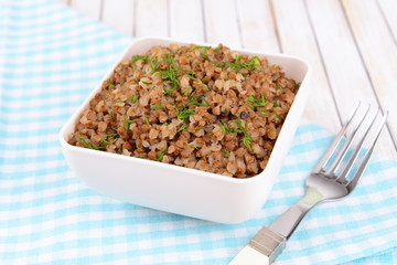 Boiled buckwheat in bowl on table close-up