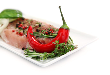 Raw meat steak with spices and herbs on plate, isolated on
