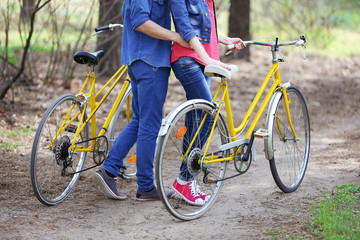 Fototapeta premium Young couple with bicycles in park