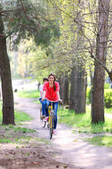 Young couple riding on bicycles in park