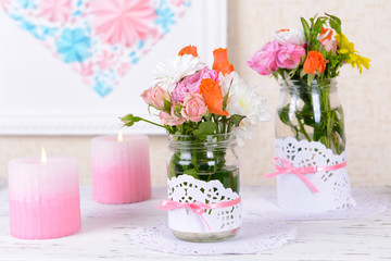 Beautiful bouquet of bright flowers in jars