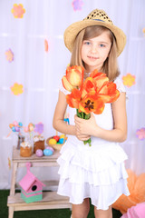 Beautiful small girl holding flowers on decorative background