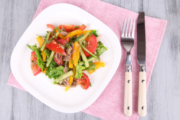 Beef salad on plate on wooden background